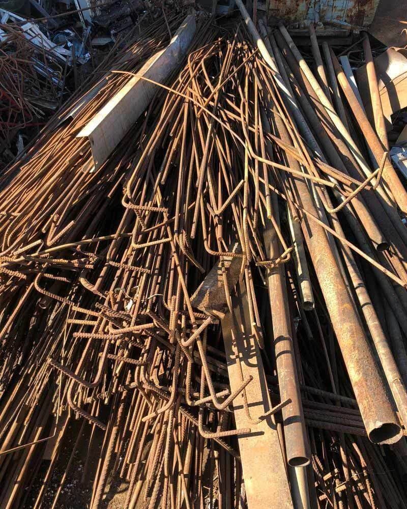 Lot de ferraille lourde : fers à béton, tubes et profilés d’acier épais stockés à l’extérieur